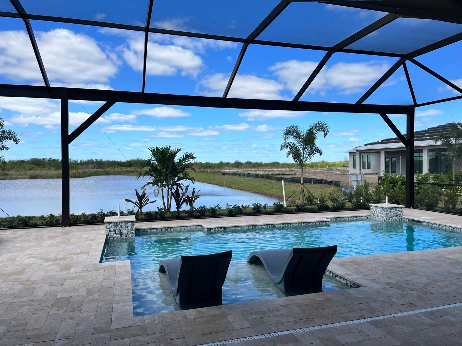 Commercial pool enclosure installation in Deltona, FL over modern resort-style swimming pool