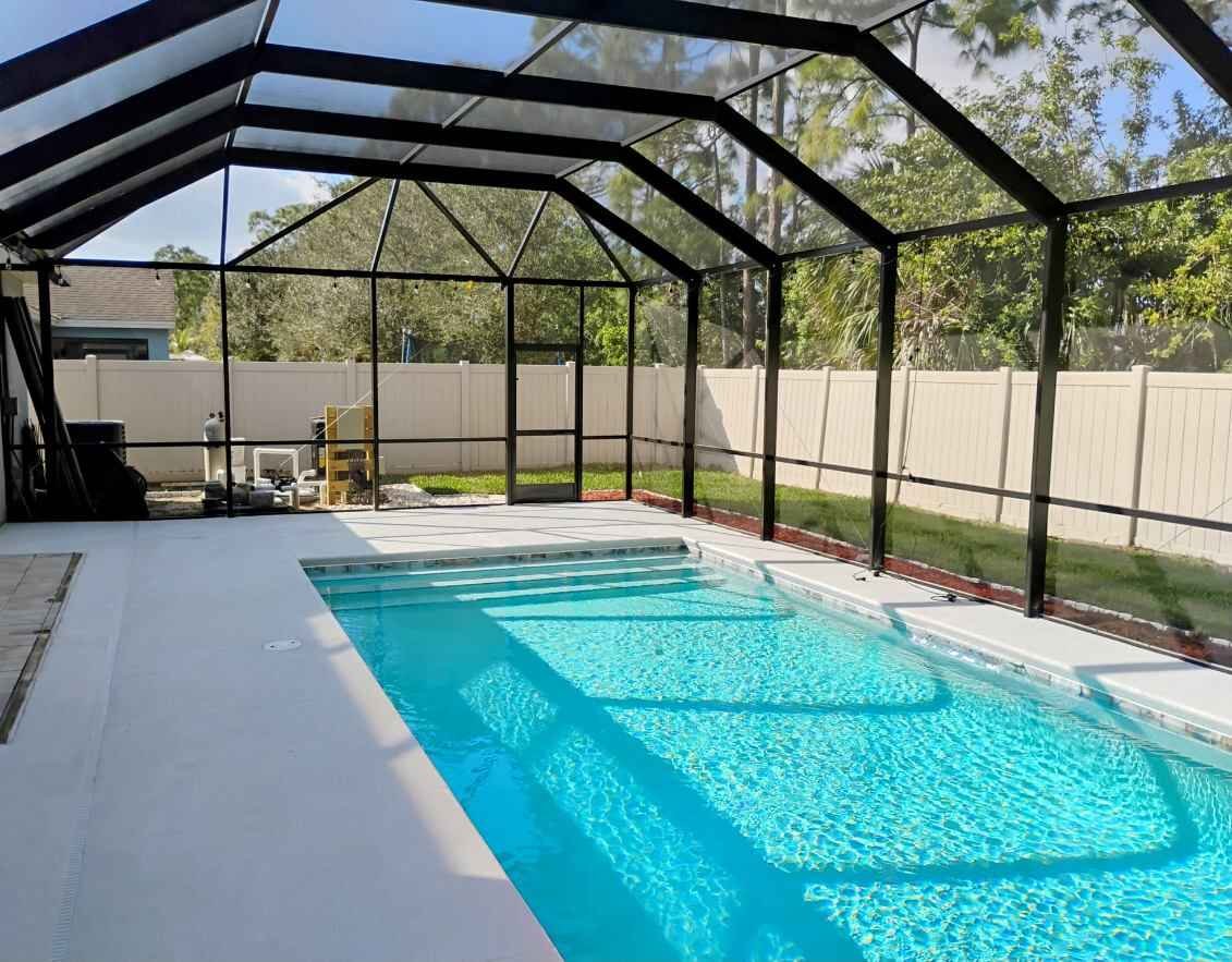 Pool screen enclosure installation in Deltona, FL surrounding residential backyard swimming pool